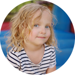 Curly little girl having fun in leisure center for kids  Child sport activity on outdoor playground  Toddler girl playing in kindergarten or entertainment centre  Kid jumping on trampoline 