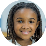 A multi-ethnic group of elementary school students are indoors in a school  They are in the classroom  They are wearing casual clothing  They are learning computer programming  They are using tablet computers to learn how to code  An Asian girl and a girl of African descent are smiling at the camera 