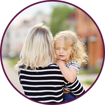 Young mother holding her little daughter standing in front of their house  Happy family together  Youthful tender mom with her cute toddler girl  Joyful motherhood
