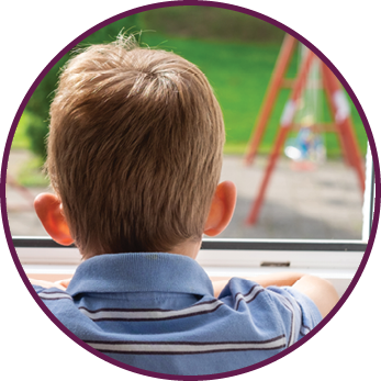 Rear view solitude boy looking to the playground through window