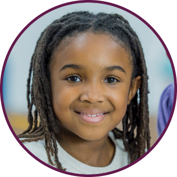 A multi-ethnic group of elementary school students are indoors in a school  They are in the classroom  They are wearing casual clothing  They are learning computer programming  They are using tablet computers to learn how to code  An Asian girl and a girl of African descent are smiling at the camera 
