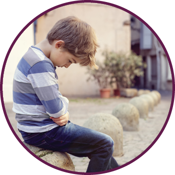 Upset problem child sitting on a street corner concept for bullying  depression  child protection or loneliness